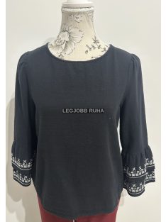   Egyenes szabású blúz, 3/4-es fodros-hímzett ujjal, kerekített nyakkivágással.